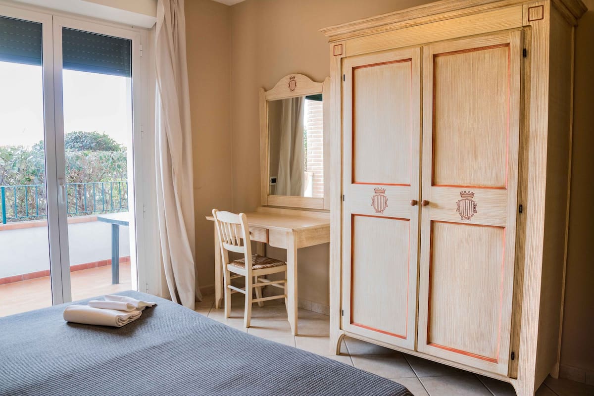 Een kamer met een bed, een bureau, een stoel en een kledingkast.