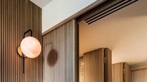 Un intérieur moderne avec un lambris vertical en bois, un luminaire central et un plancher en bois.
