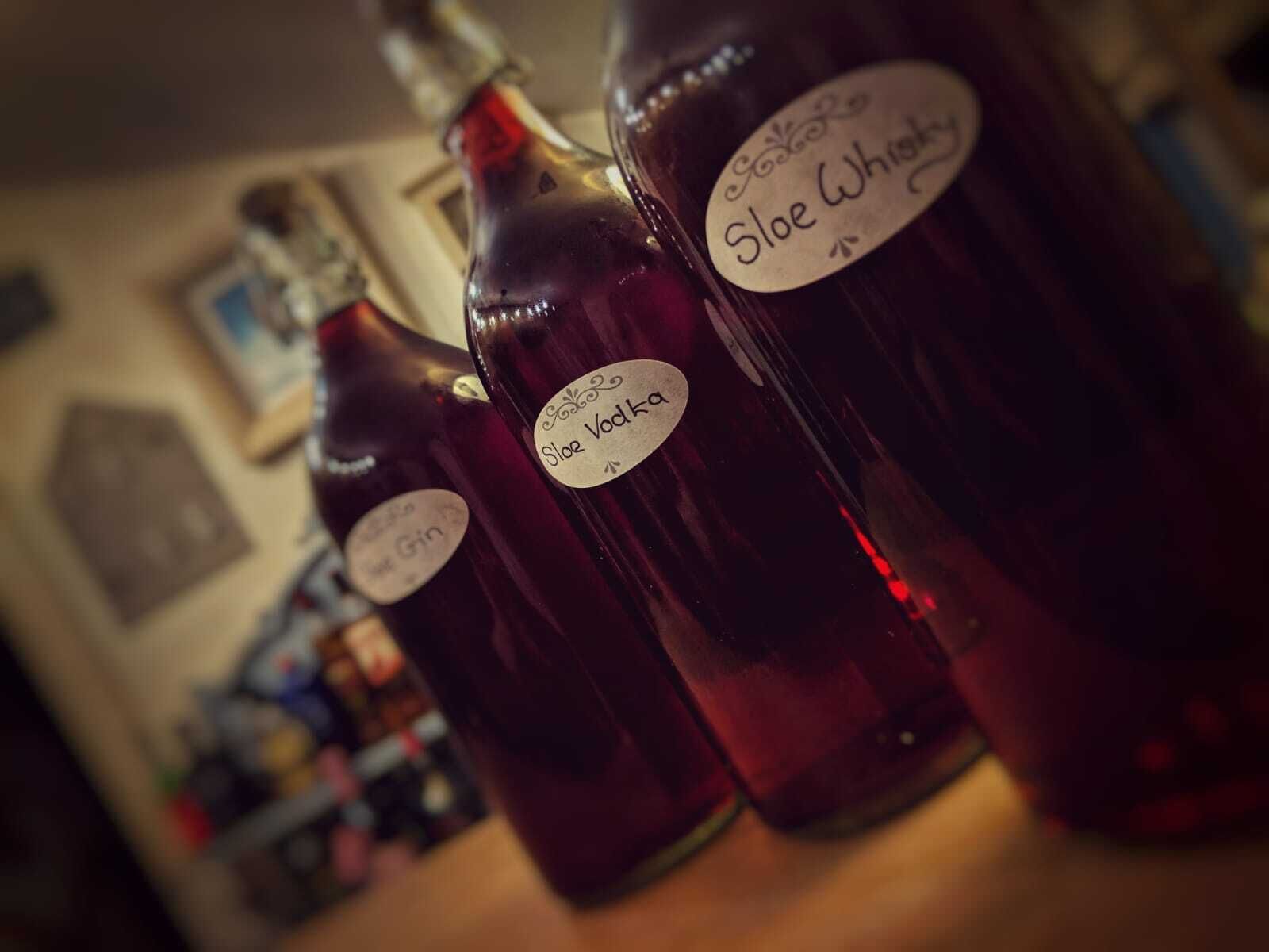 Drie flessen Sloe Vodka op een barkruk.