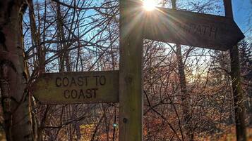 Un cartel de madera con flechas direccionales y el texto 'COAST TO COAST' y 'PATH'.