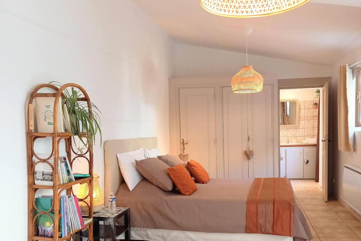 Une chambre à coucher avec un lit, une table de chevet et une bibliothèque.