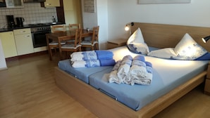 A bedroom with a bed, pillows, and a bedside lamp.