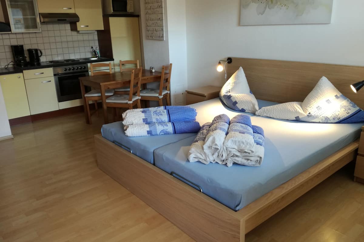 Un dormitorio con cama, almohadas y lámpara de noche.