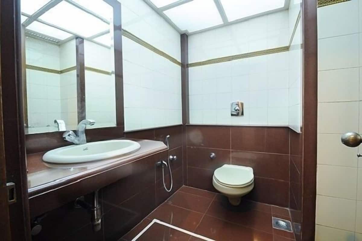 Un baño con lavamanos blanco, inodoro y espejo.