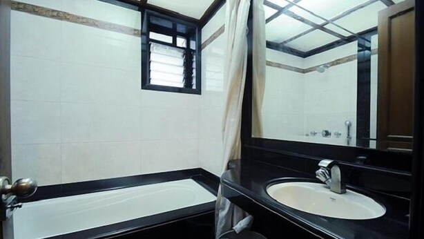Une salle de bain avec une baignoire, un lavabo et un miroir.