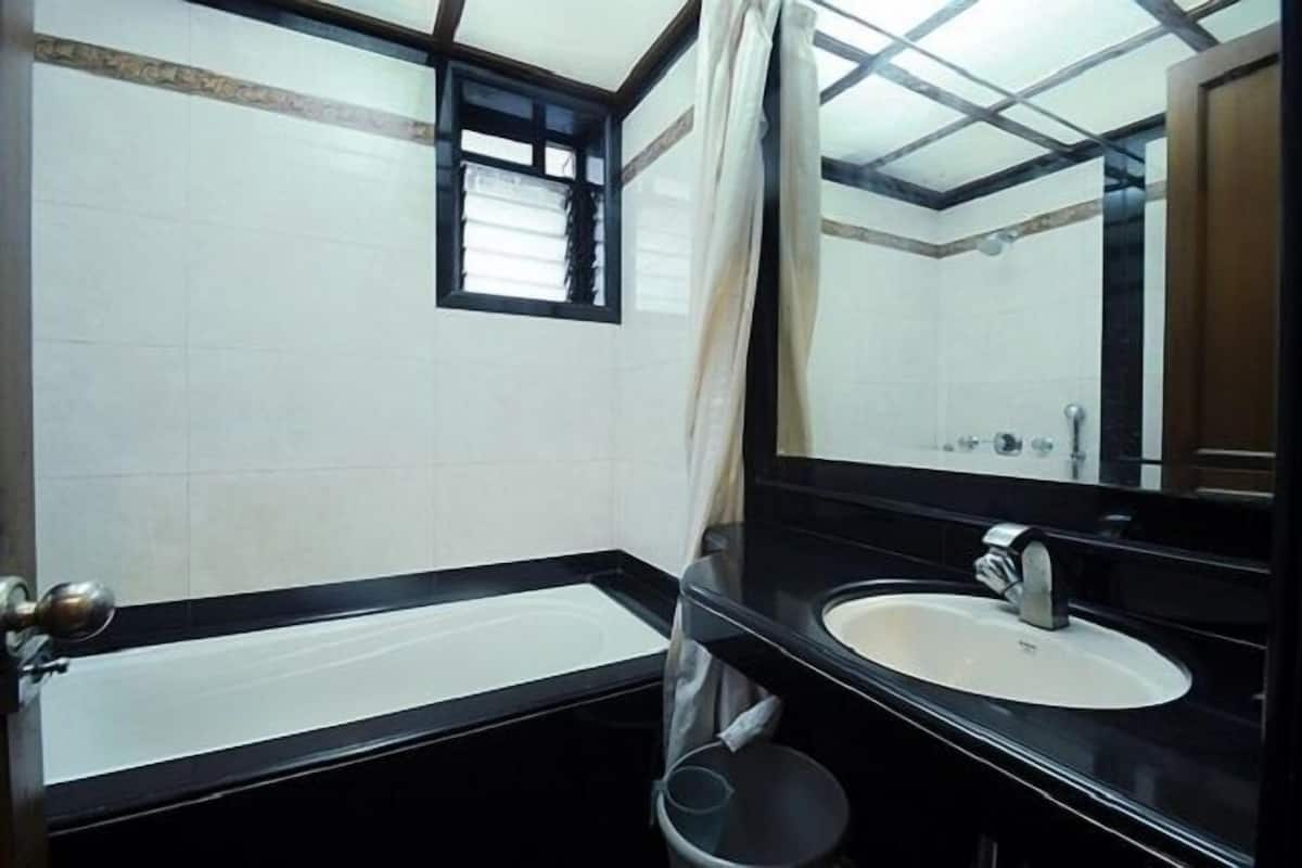 Un baño con bañera, lavamanos y espejo.
