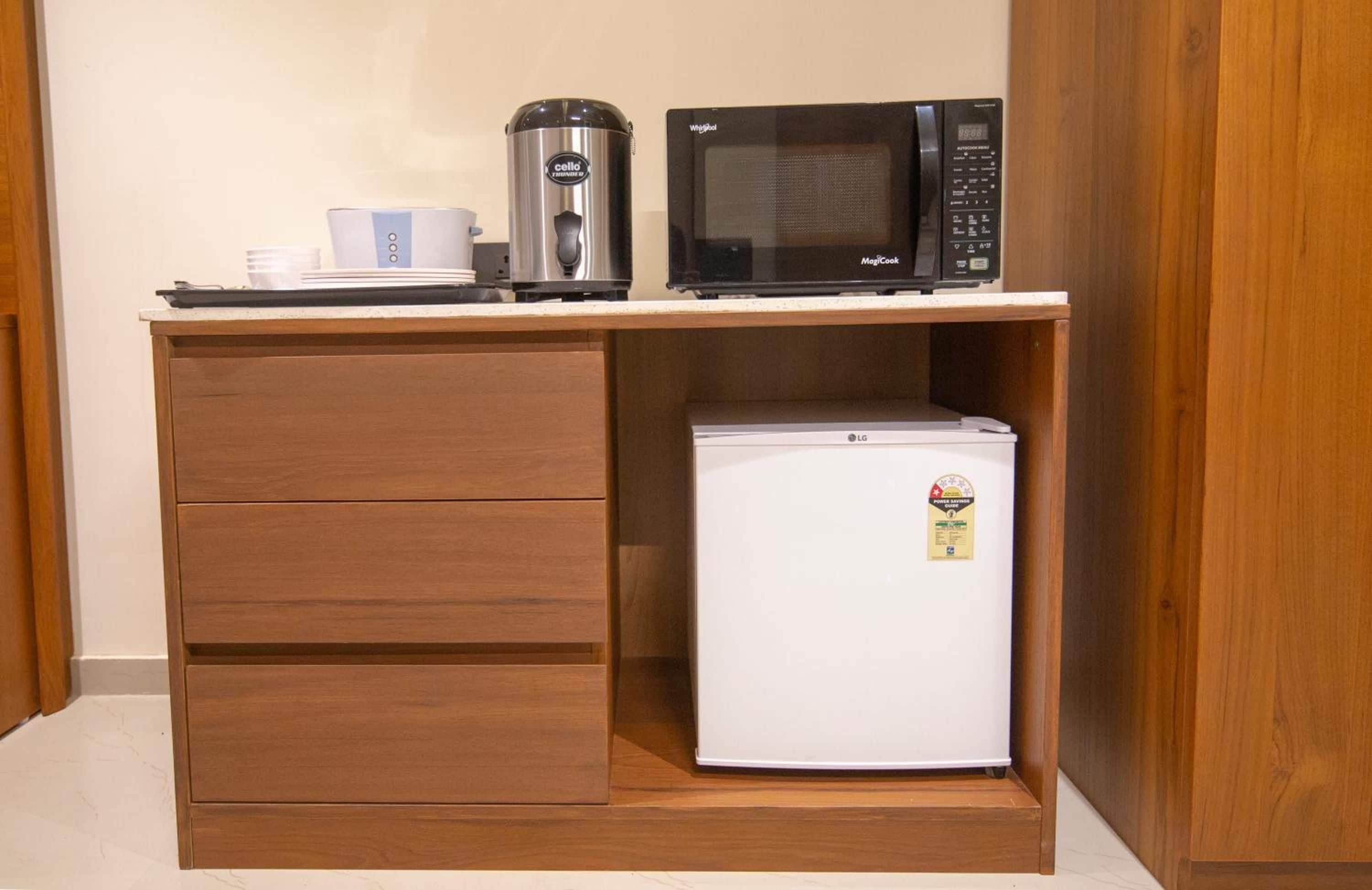A kitchenette with a microwave, a coffee maker, and a refrigerator.