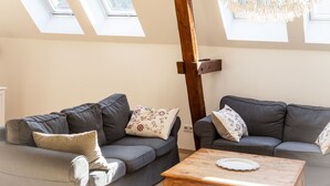 A room with two grey sofas, a wooden coffee table, and a wooden beam structure. - Landhof Potsdam (Potsdam)