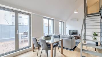 Un apartamento moderno con comedor, sala de estar y una escalera.