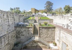 Una escalera de piedra que conduce a una terraza en la azotea, con asientos al aire libre y vistas de los edificios circundantes.