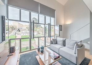 Premium loft, 1 queensize bed, toegang tot zwembad, uitzicht op zwembad | Woonkamer | Flatscreentelevisie