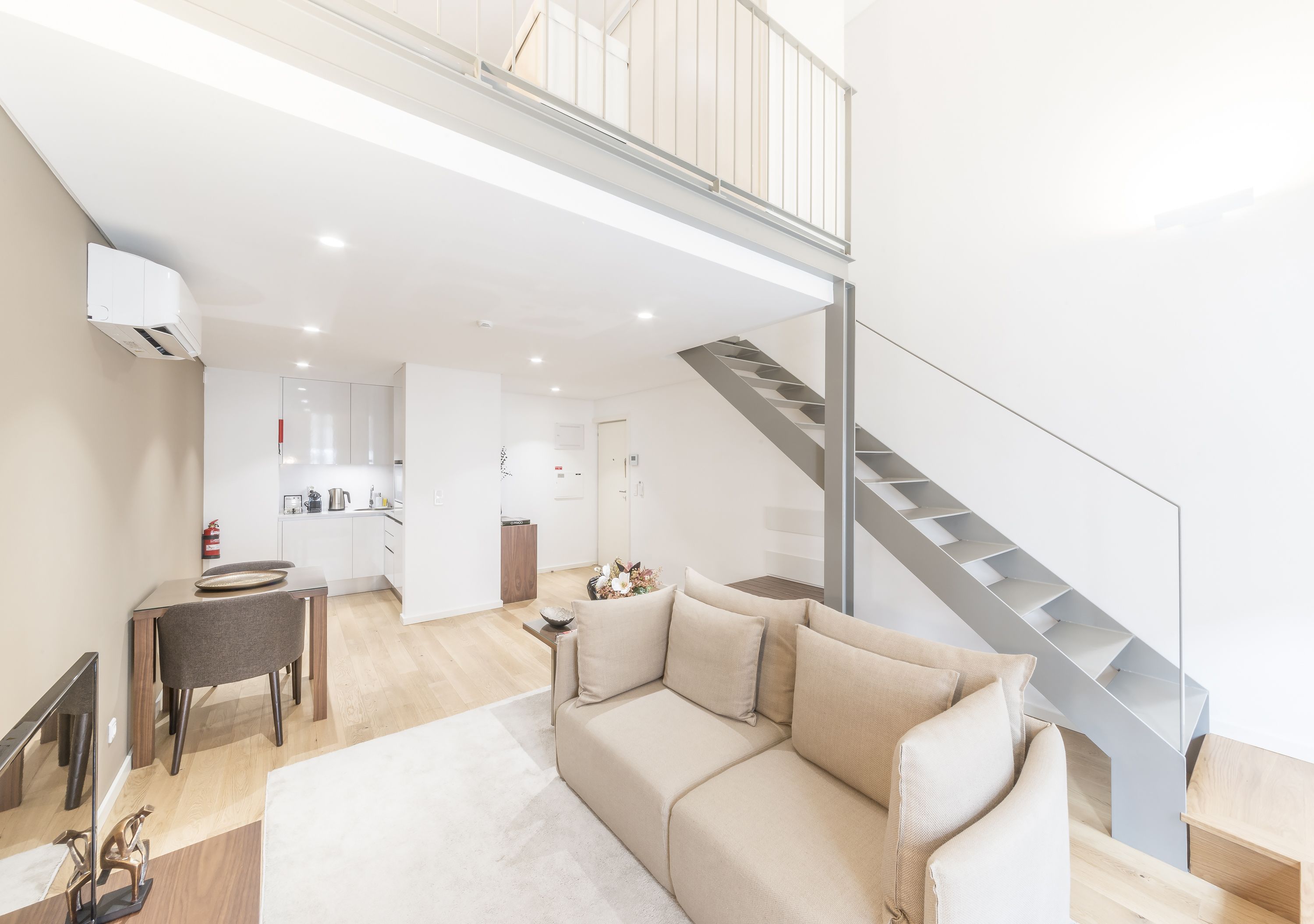 Un appartement moderne comprenant un espace de vie, une cuisine et un escalier.