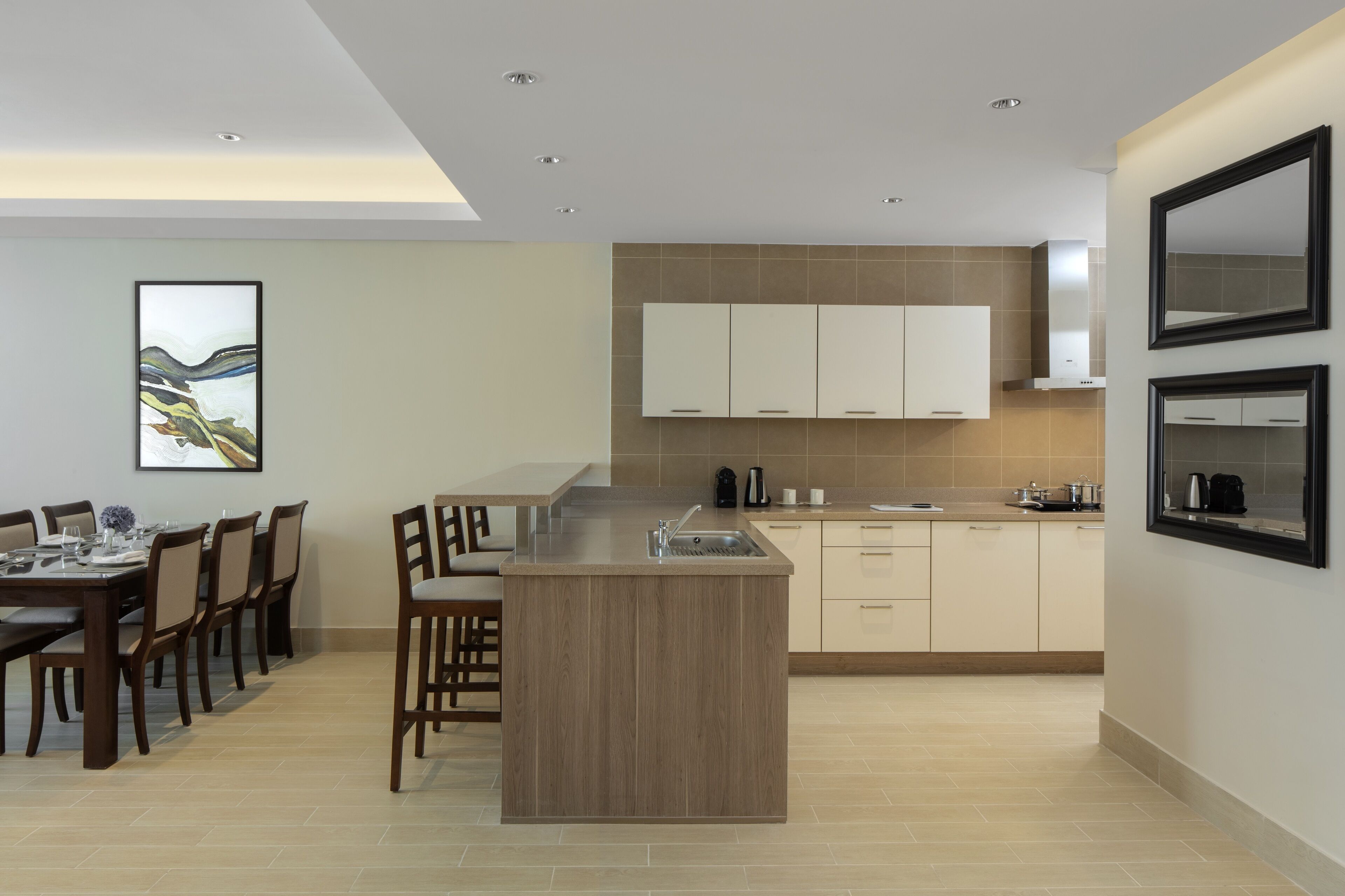 Una cocina moderna con una isla central, armarios empotrados y un comedor con sillas y una mesa.
