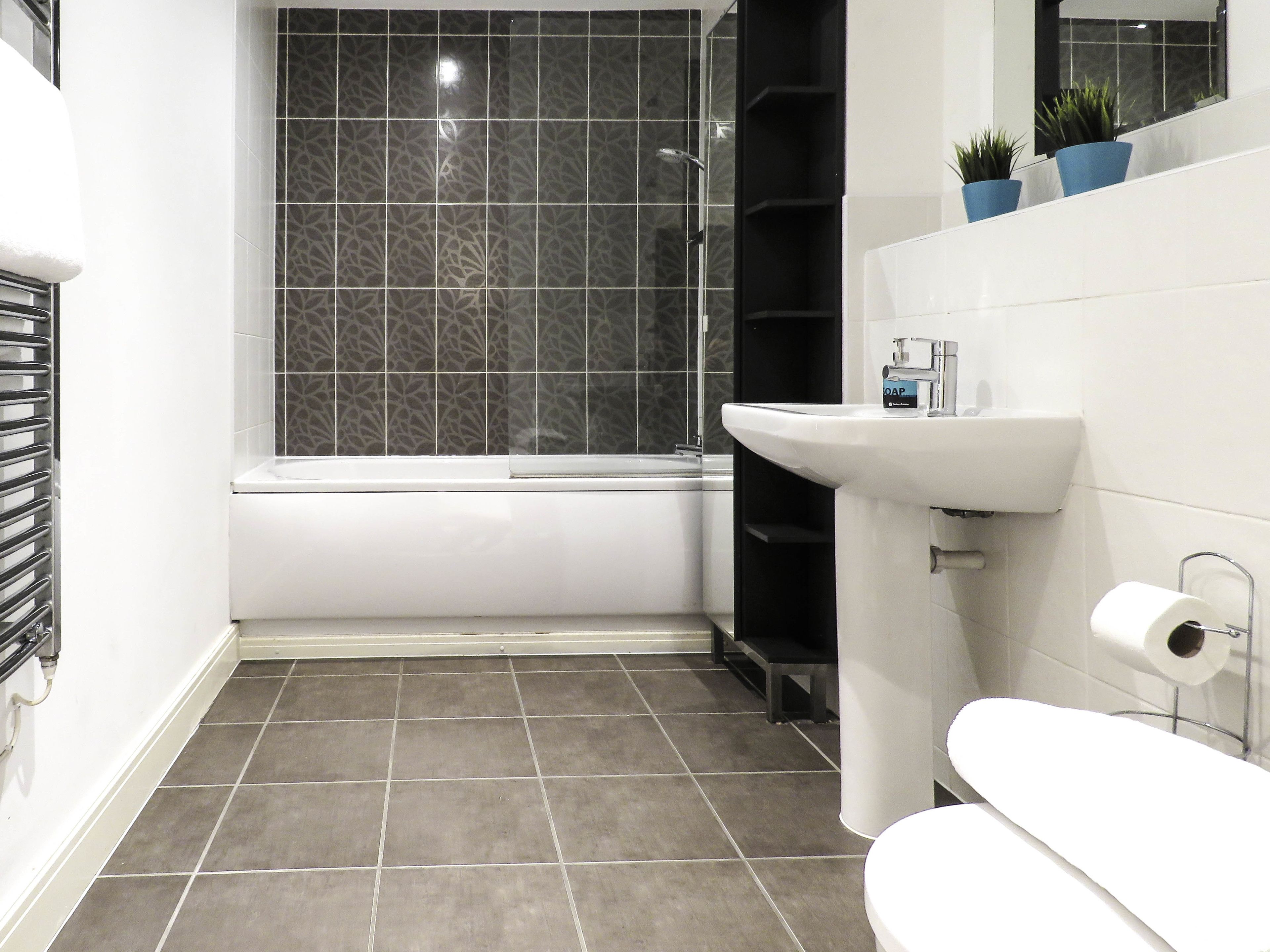 A modern bathroom with a bathtub, a sink, and a toilet.