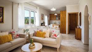 Ein Wohnzimmer mit Sofa, Couchtisch und Blick auf die Küche.