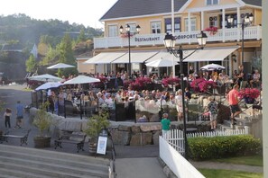 A restaurant with outdoor seating, a white fence, and steps leading up to the entrance. - Hotel Lyngørporten (Tvedestrand)