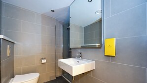Un baño moderno con inodoro, lavamanos y ducha.