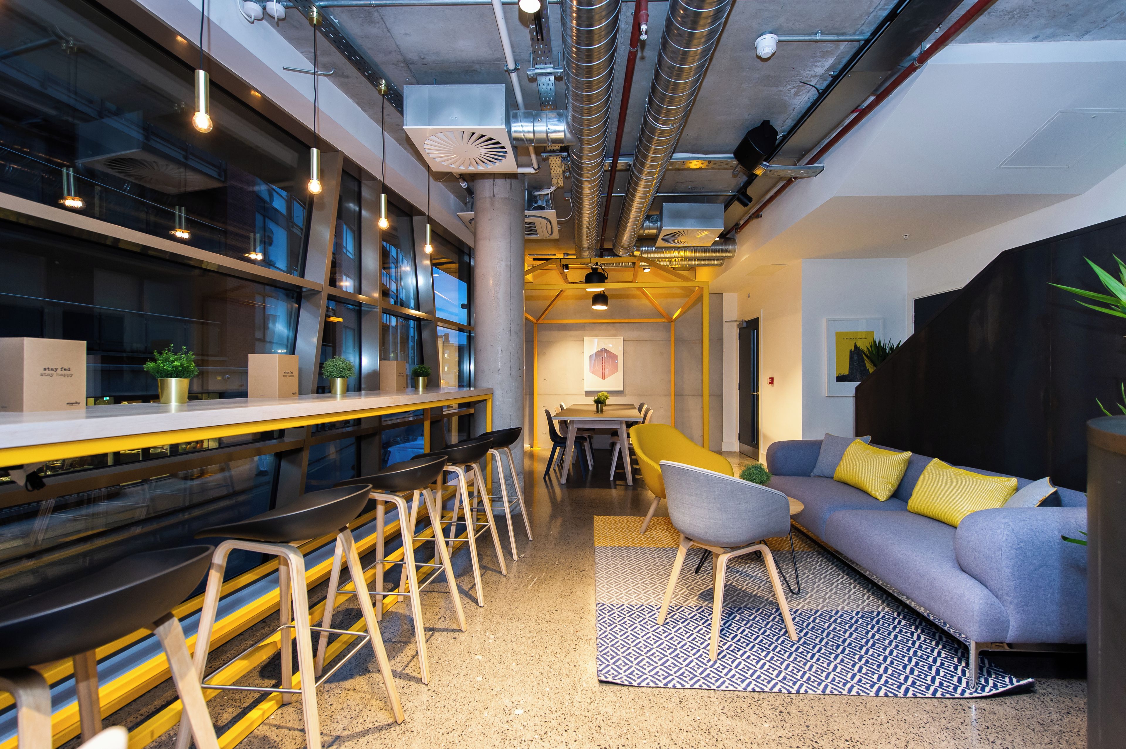 Un interior moderno con una zona de bar, asientos y un sofá.