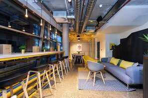 Un intérieur moderne avec un bar, des sièges et un canapé.