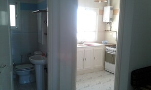 A compact kitchen with a sink, stove, and cabinets. - Residence MahdiaSquare (Mahdia)