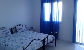 A bedroom with a bed, curtains, and a window. - Residence MahdiaSquare (Mahdia)