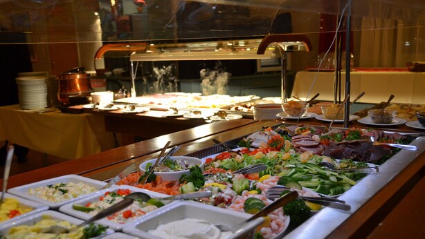En buffet med et bredt udvalg af mad, herunder salater, kød og fisk.