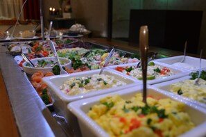 A buffet with various food options including salads, seafood, and other dishes.