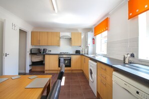 Oppvaskmaskin, høy barnestol og kjøkkenutstyr