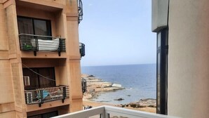 A high-rise apartment with multiple balconies overlooking a beach. - Gold Lion Residensea (St. Julian's)