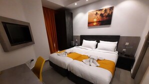 A hotel room with a bed, a desk, and a TV. - Gold Lion Residensea (St. Julian's)