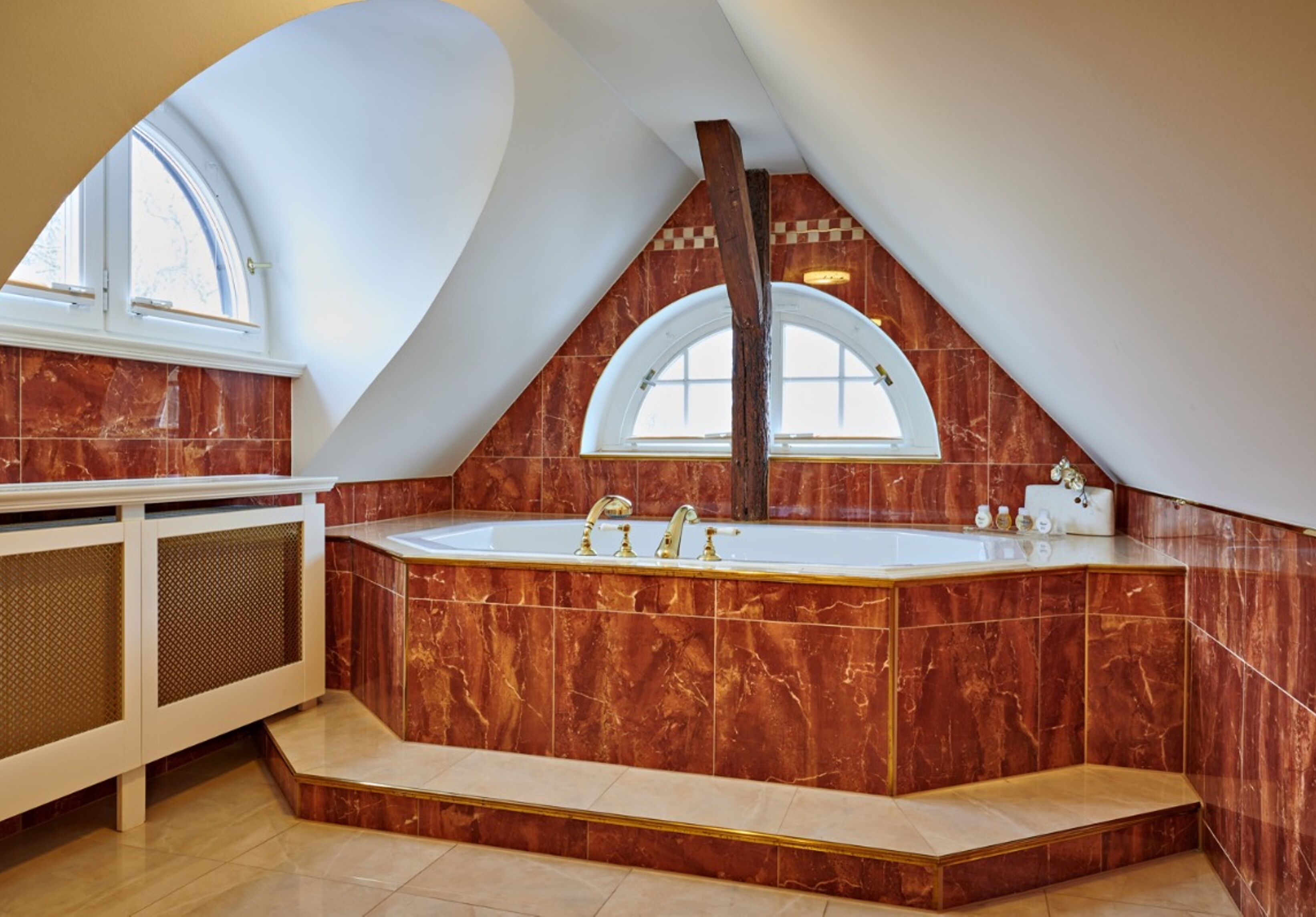 A modern bathroom with a freestanding bathtub, marble walls, and a large window.