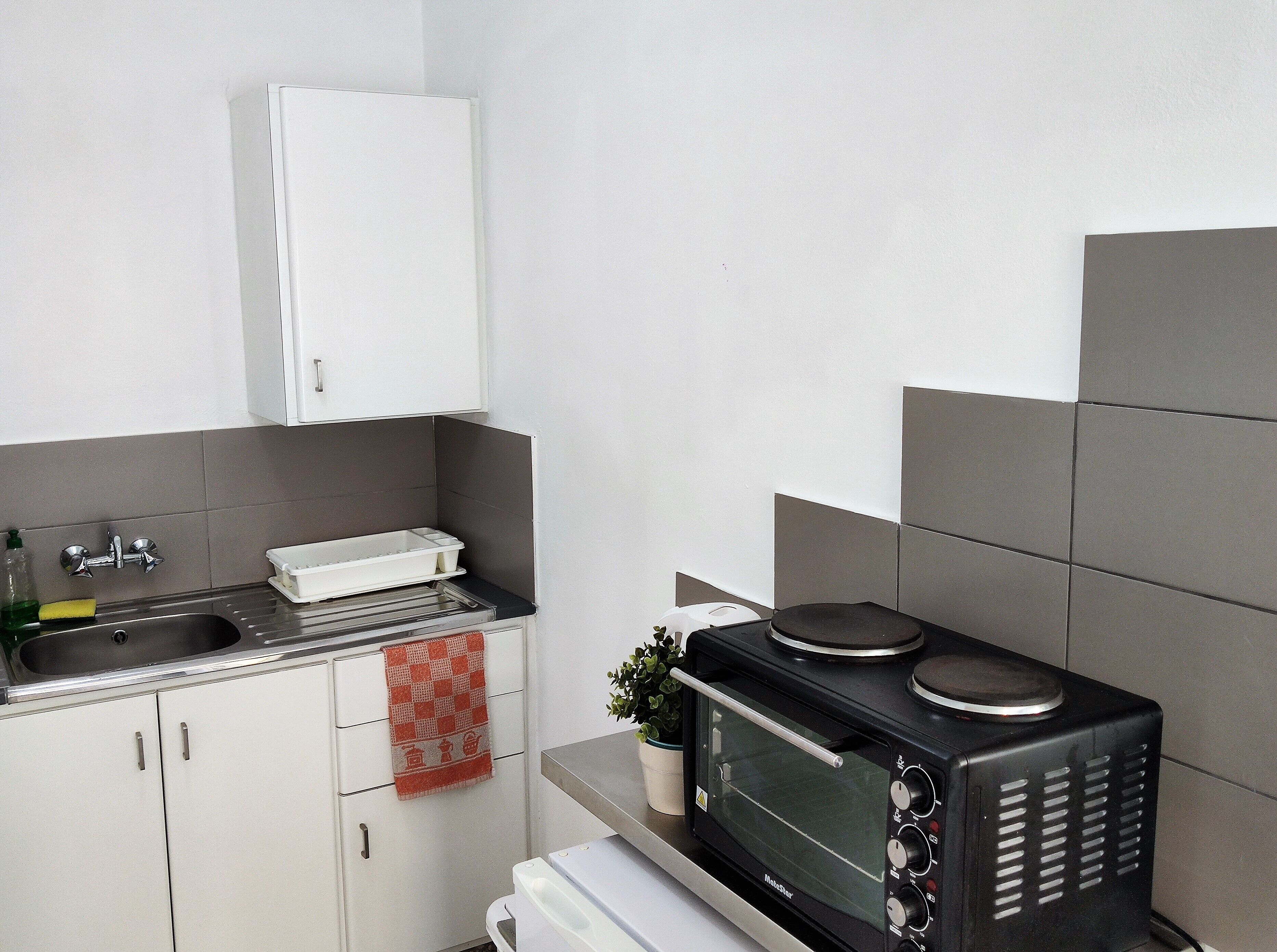 A compact kitchen with a built-in microwave, a sink, and a small countertop.