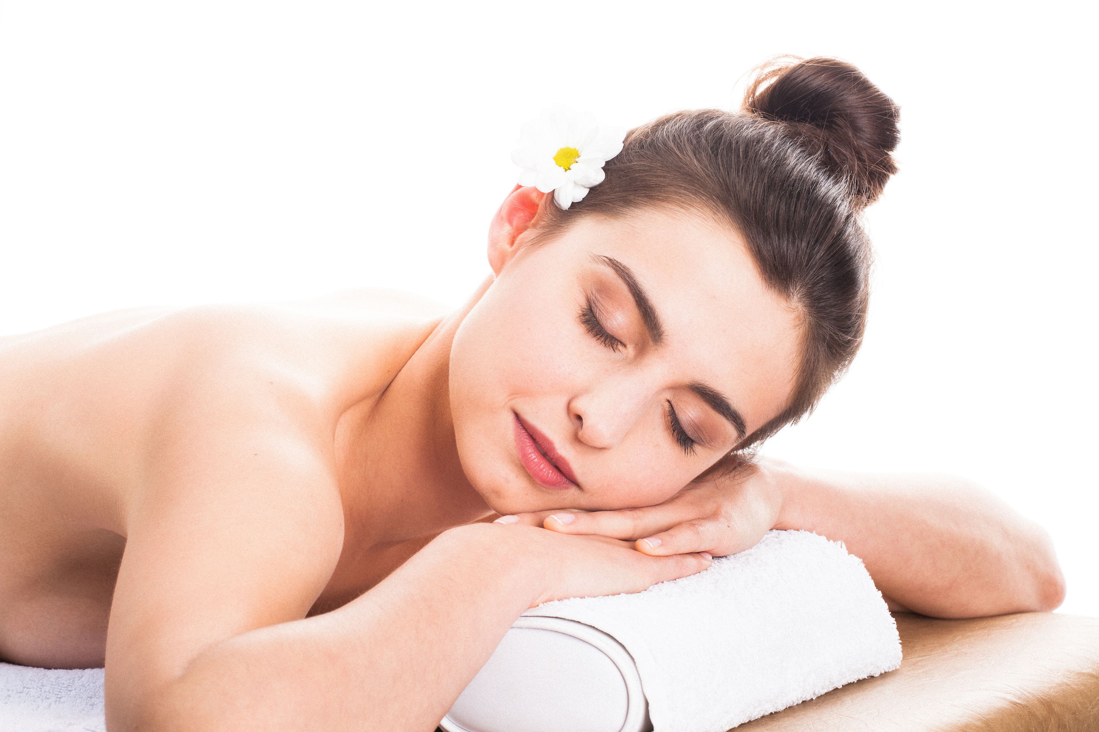 A person lying on a massage table with a towel, suggesting a spa setting.