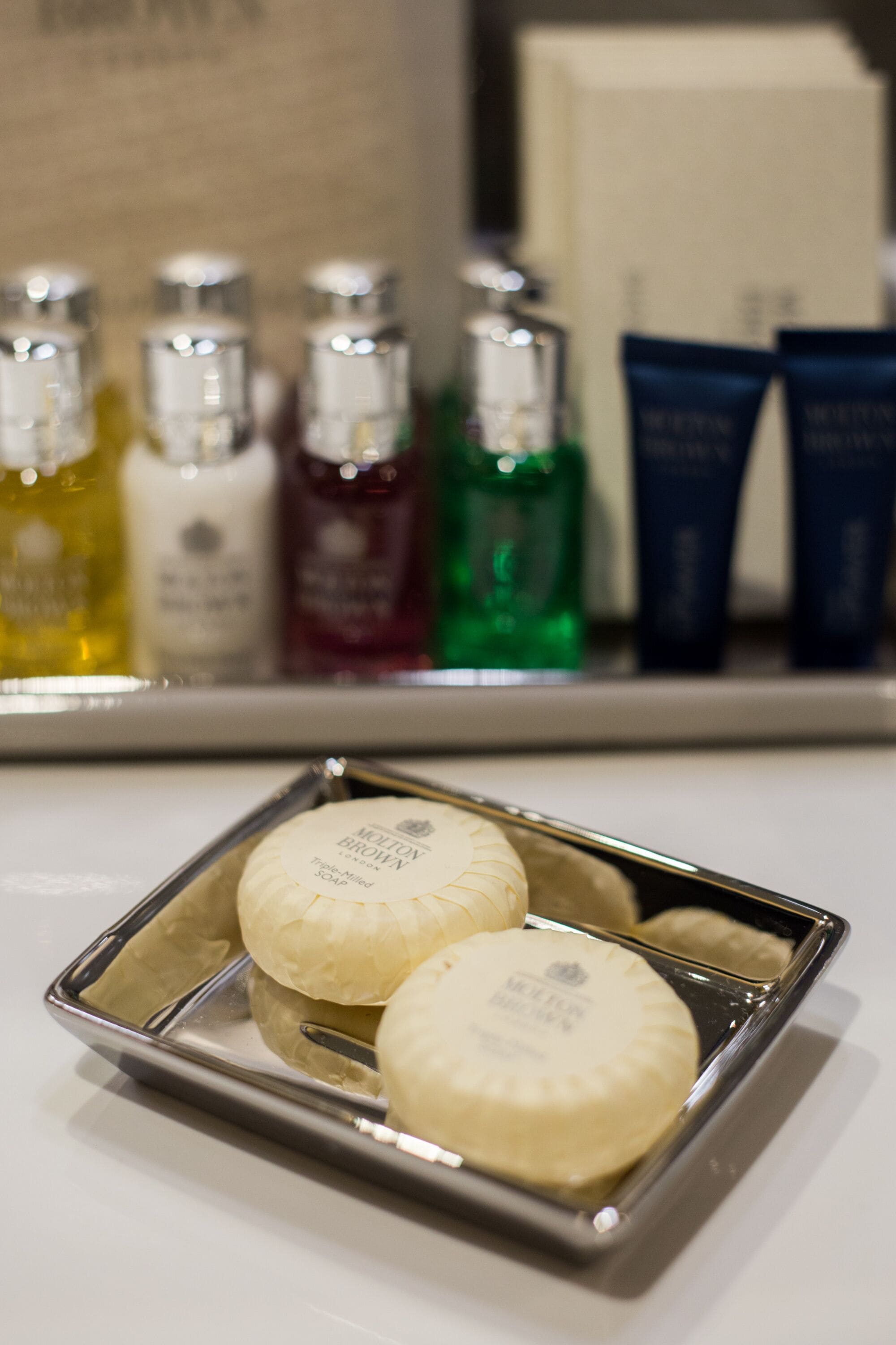 A tray with two soap bars and a bottle of lotion.