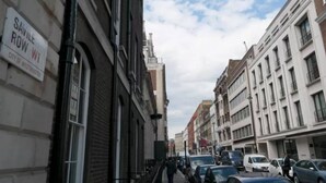 A street view with buildings, a sign for Savile Row W1, and parked cars. - Luxury Mayfair 2 Bedroom Apartment (London)