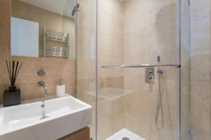 Apartamento (2 Bedrooms) | Baño | Ducha, artículos de higiene personal gratuitos y secador de pelo