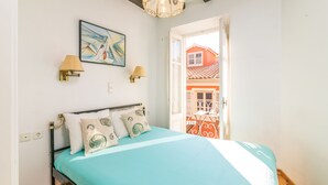 Un dormitorio con una cama, dos lámparas de pared, una lámpara de techo y un cuadro.
