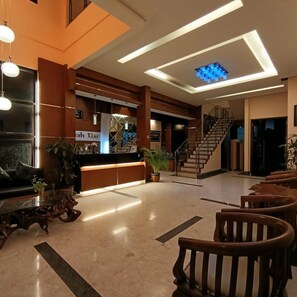 A spacious lobby with a reception desk, a staircase, and a modern ceiling design. - Omahqu Guest House (Yogyakarta)
