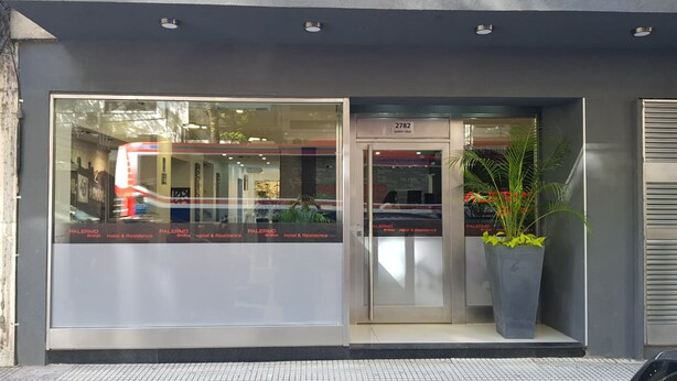 A hotel entrance with a large glass window displaying the name 'PALERMO Bridge Hotel & Residence'. - Palermo Bridge (Buenos Aires)