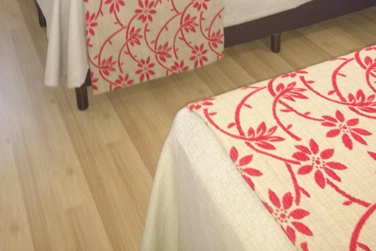 Un dormitorio con cama, televisión, armario y espejo.