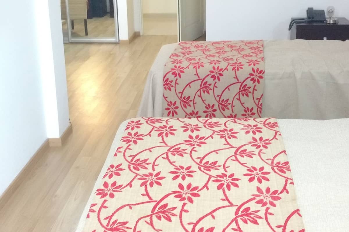 Una habitación de hotel con una cama, un escritorio y un espejo.
