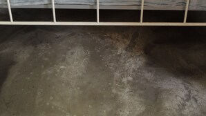 Una cama con estructura metálica blanca y colchón azul.