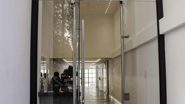 A modern hallway with glass doors, a patterned floor, and a ceiling with recessed lighting. - Avellaneda Aparts & Suites (Buenos Aires)