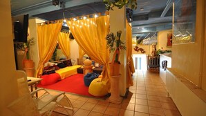 A cozy room with a red carpet, yellow curtains, and a bed with colorful pillows. - Themenhotel Terrassen Café (Bad Muender am Deister)