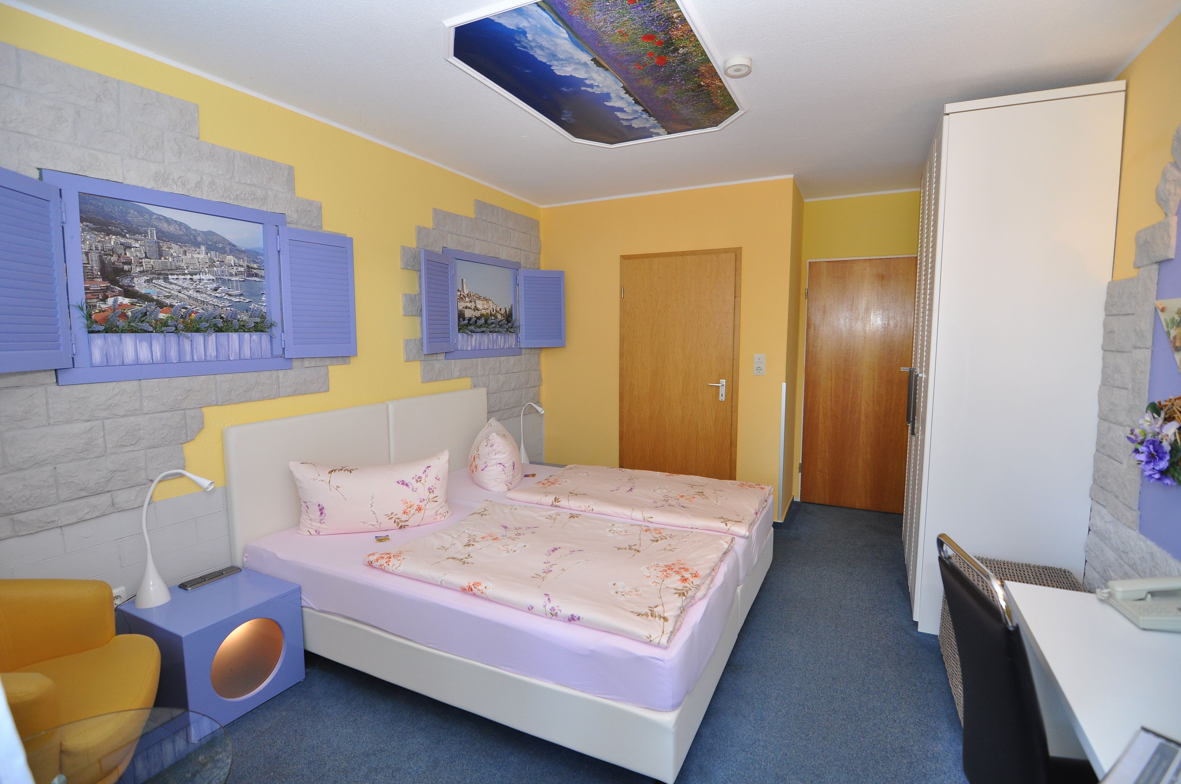 Ein Schlafzimmer mit einem Bett, einem Nachttisch, einem Schreibtisch und einem Stuhl.