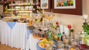 A buffet with various food items and beverages, including fruits, cereals, and condiments. - Themenhotel Terrassen Café (Bad Muender am Deister)