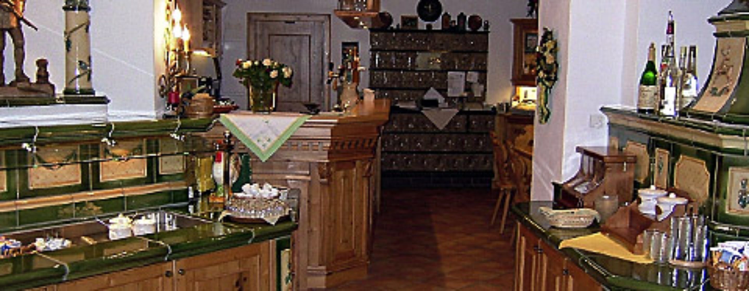 A narrow hallway with wooden cabinets and shelves filled with various items.