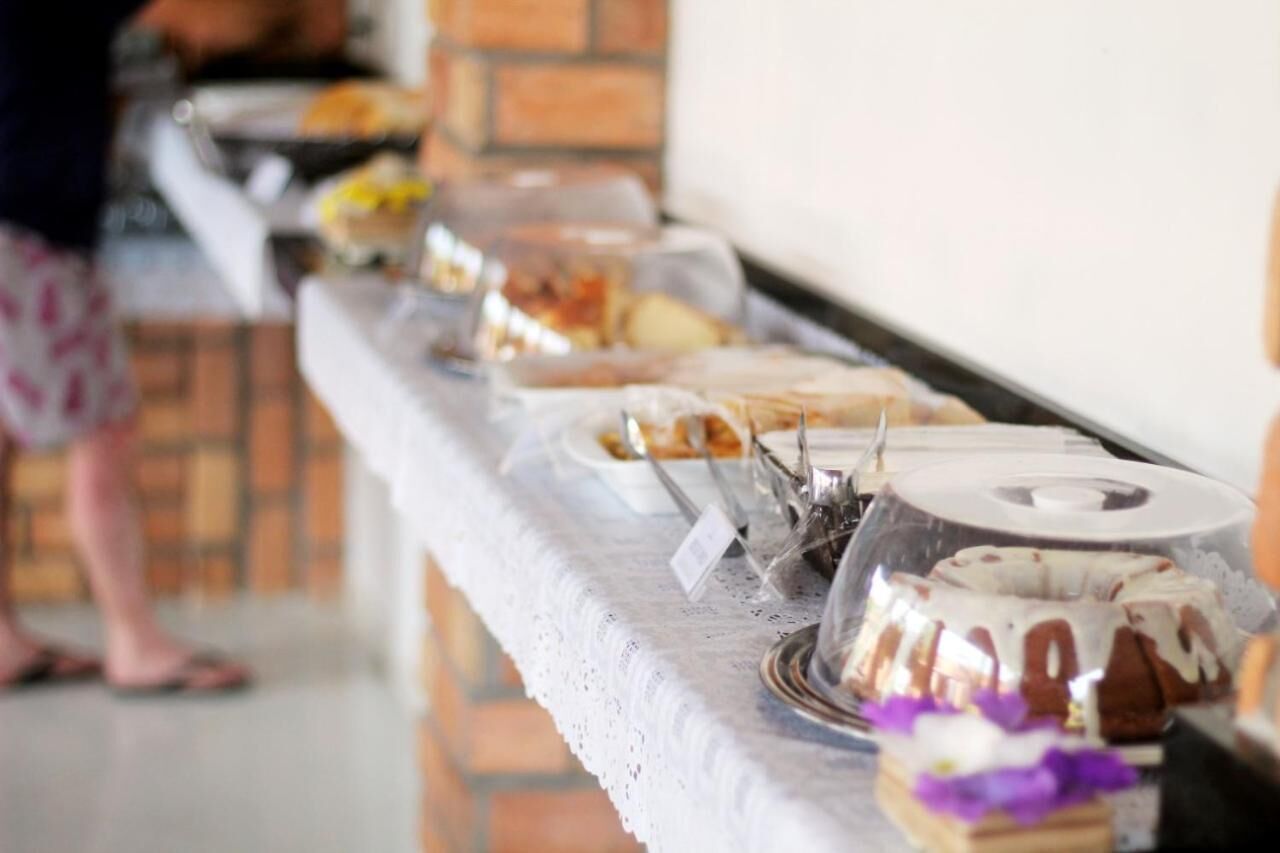 Una mesa de buffet con diversos platos y un pastel, frente a una pared de ladrillo.