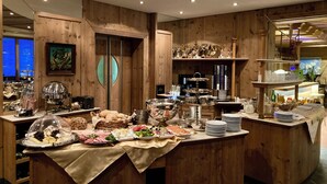 A buffet setup with various food items and a display of trophies. - Alpenhotel Seiler (Silz)