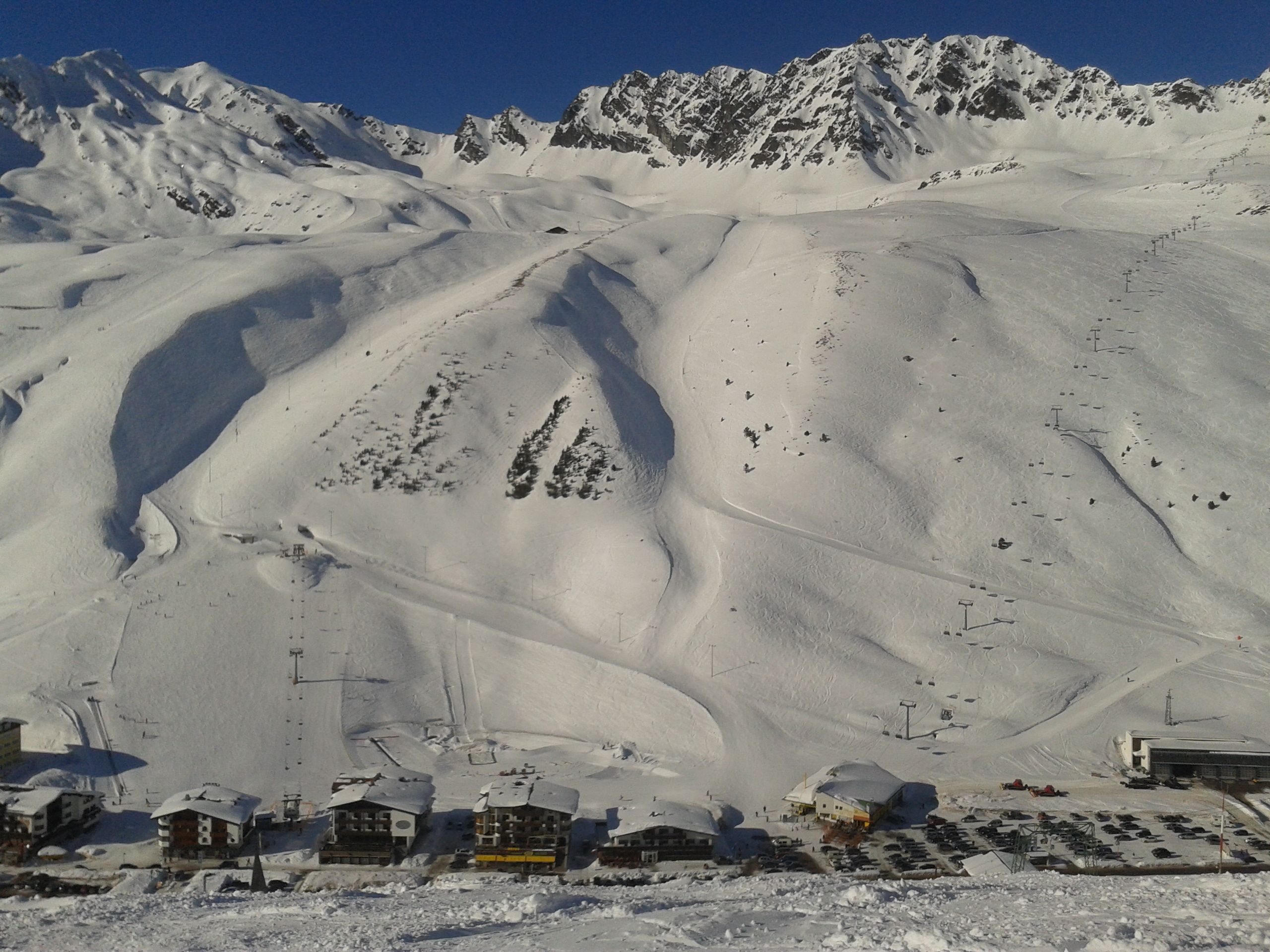 A snow-covered mountain with ski slopes and a small village at the base.